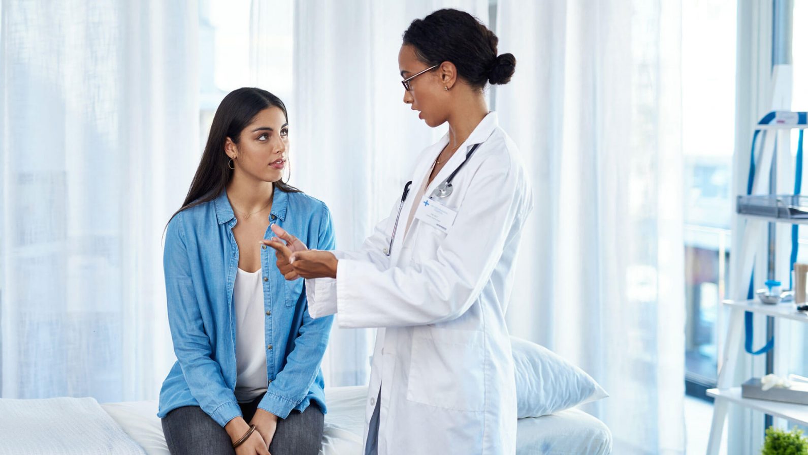 Médica conversando com paciente sobre doenças agudas